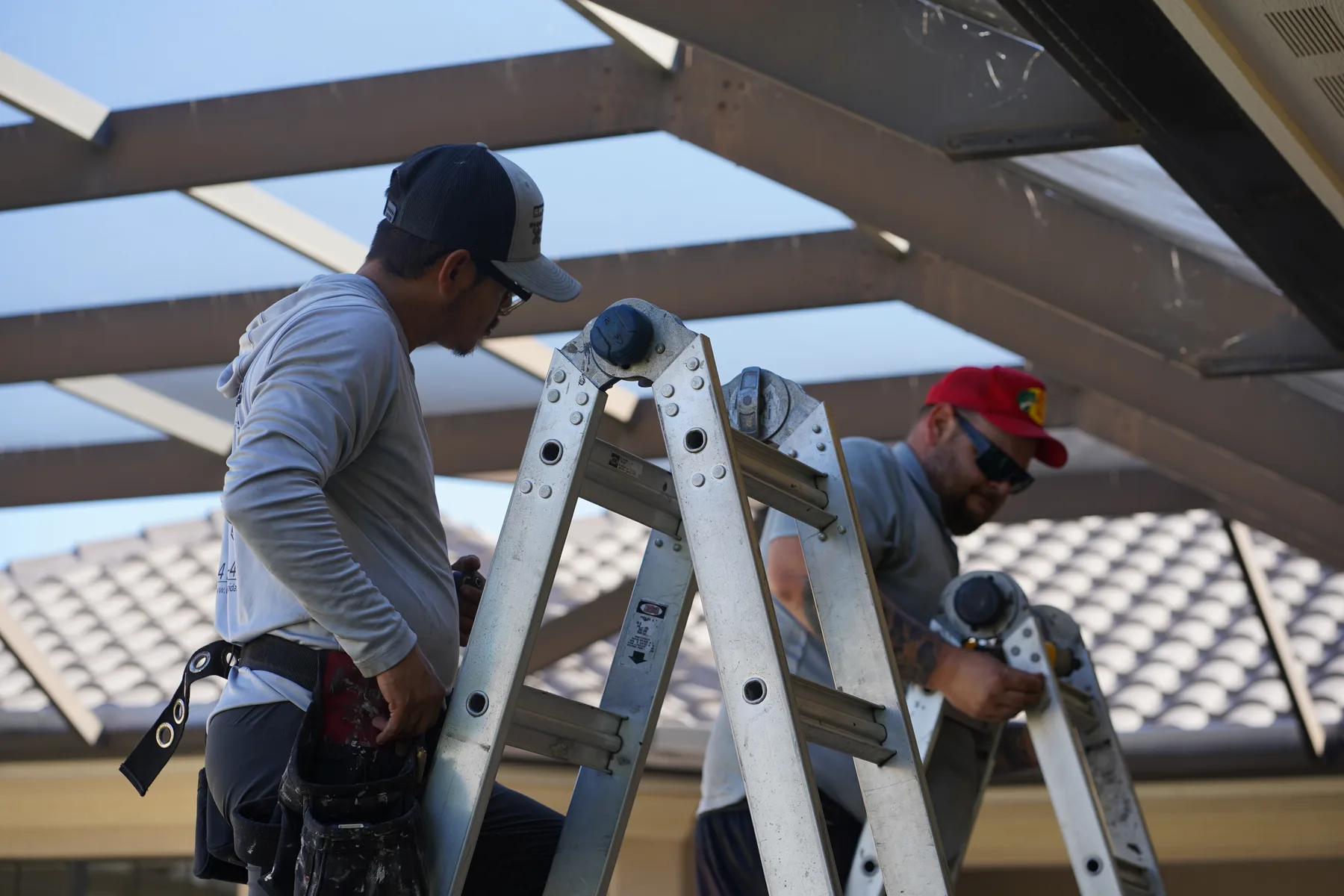 Crew installing screen across a large custom pool enclosure