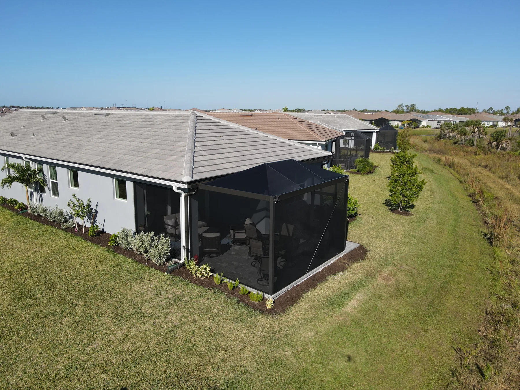 Detailed aerial view of a screened lanai and patio furniture