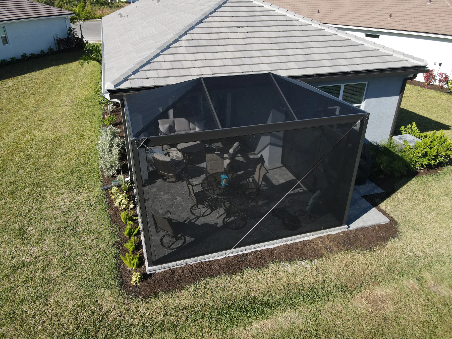 Finished dark-frame screened lanai viewed from the backyard